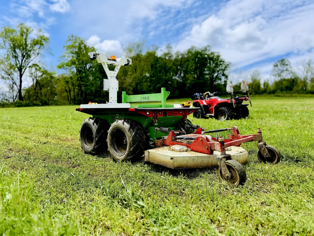 A Burro robot mowing a grass field during a field test