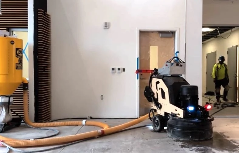 A Tempo Works robot grinding a concrete floor on a job site